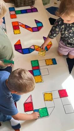 two children are playing with colored blocks on the floor