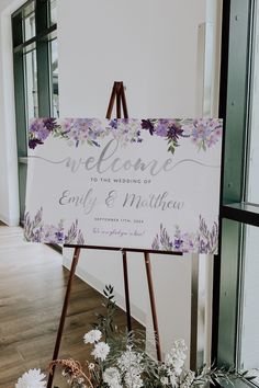 a welcome sign sitting on top of a wooden easel