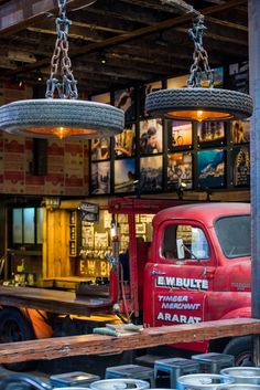 an old red truck is being worked on in a garage with other trucks and equipment