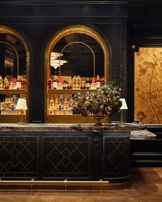 the bar is decorated in black and gold with vases on it's counter