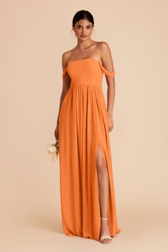 a woman in an orange dress with one leg slited and the other side split open