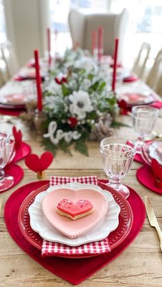 a table set for valentine's day with red and white place settings