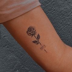 a woman's arm with a rose tattoo on the left side of her arm