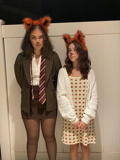 two girls dressed up in costumes standing next to each other with their hands on their hipss