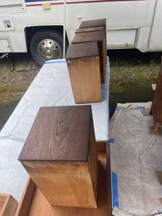 several pieces of wood sitting on top of a table next to a white truck and grass