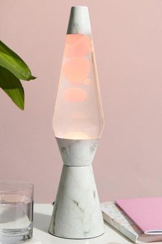 a white table with a marble lamp on it and a pink wall in the background