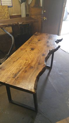 a wooden table sitting inside of a room next to a metal frame door and window