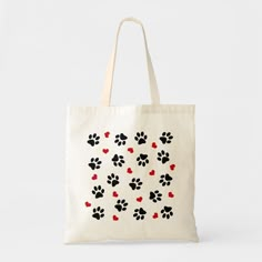 a white bag with black and red paw prints on the front, and hearts in the back