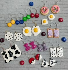 several different earrings are laid out on the floor next to some cookies and doughnuts