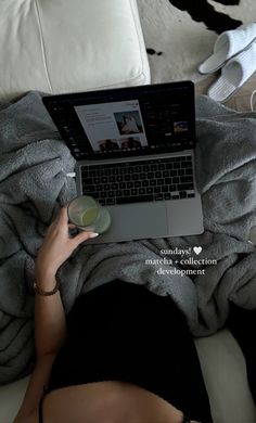 a woman laying on top of a bed using a laptop computer