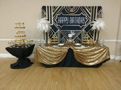 a table topped with gold and black desserts on top of a hard wood floor