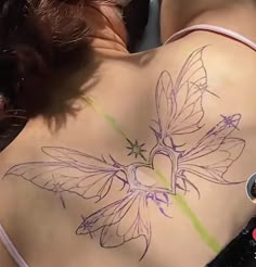 a woman with a butterfly tattoo on her back