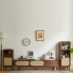 a living room with white walls and wooden furniture in front of a clock on the wall