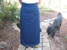 a woman standing next to a gray dog