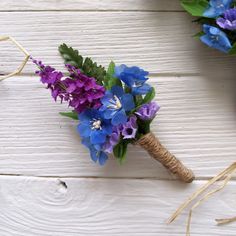 purple and blue flowers are tied to a piece of burlock with twine