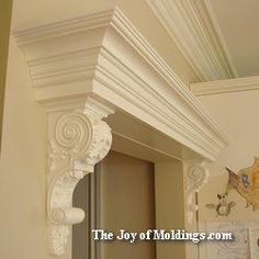 an ornate white corbge above a mirror in a room