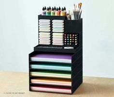 a black desk organizer with lots of pens and markers on it's trays