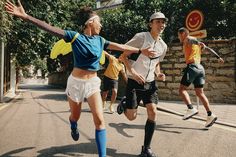 people are playing soccer in the street with their arms out and one person has his leg up