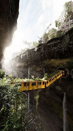 a yellow train traveling through a tunnel next to a lush green hillside covered in trees