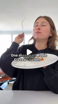 a woman is holding a plate with food on it and she has her eyes closed