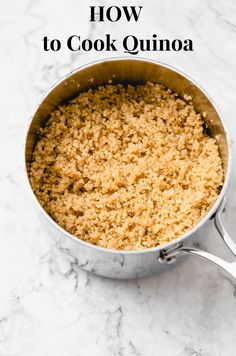 a pan filled with food sitting on top of a marble countertop next to a spoon