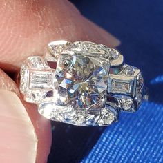 a close up of a person's hand holding a diamond ring