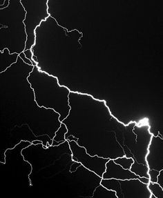 lightning strikes across the night sky in black and white