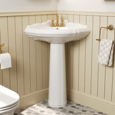 a white pedestal sink sitting next to a toilet