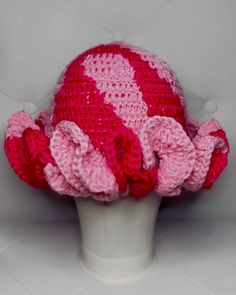 a crocheted hat with pink and red flowers on it's brim