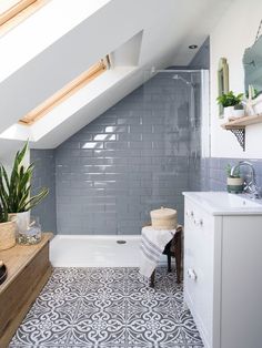 a bathroom with blue and white tiles on the floor, sink, toilet and bathtub