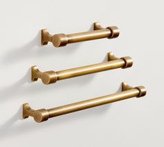 three brass - plated handles hang on the wall