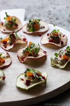 small appetizers are arranged on a plate with garnishes and vegetables