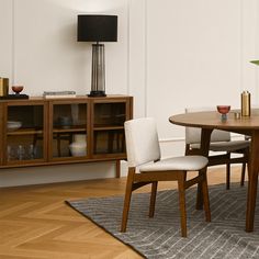 a dining room table with chairs and a lamp