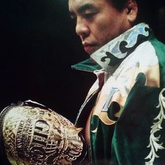 a close up of a person wearing a jacket and holding a wrestling ring in his hand