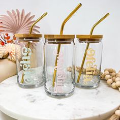 three personalized tumblers with gold straws are sitting on a table