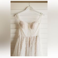 a white dress hanging up against a wall