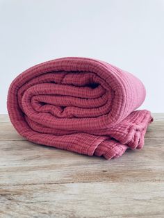 a pink towel folded on top of a wooden table