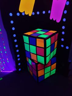 a rubik cube in the middle of a room with neon lights and decorations around it