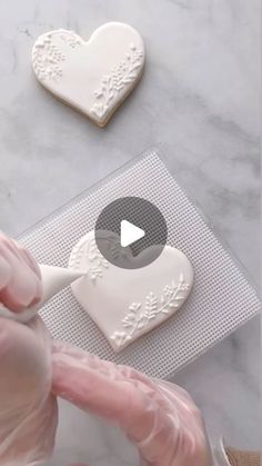 someone is decorating cookies with white icing