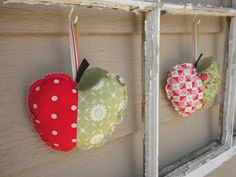 three apples hanging on the side of a window sill with polka dots and hearts