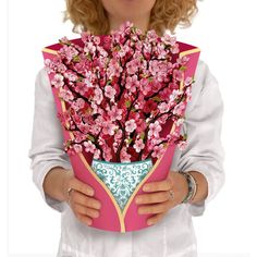 a woman holding a card with pink flowers in it