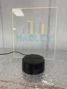 an electronic device sitting on top of a table next to a sign that says hadley