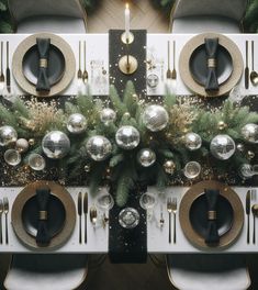 the table is set for christmas dinner with silver and gold decorations