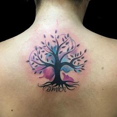 a woman's back with a tree tattoo on it