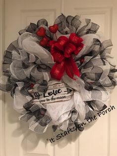 a mesh wreath with red and white hearts hanging on the front door for valentine's day