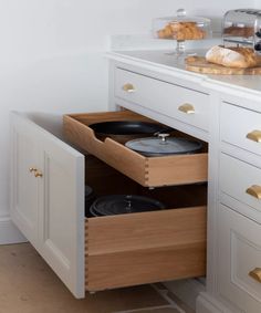 an open cabinet with two pots and pans in it