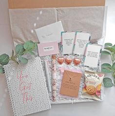 the contents of a gift box are laid out on top of a white tablecloth