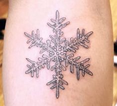 a snowflake tattoo on the leg