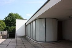 an empty balcony with glass doors and trees in the background