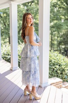 Light blue floral print layer tiered midi dress with decorative bow on bodice You will feel just like a princess in this Sweet Florals Blue Midi Dress! She's so delicate, and pretty with white and light blue floral print, large bow on the ruched bodice, and layer tiered skirt. The perfect Summer dress for all of your upcoming celebrations - from Wedding events to summer vacations and everything in between! Fits true to size; flowy skirt Model is 5'5" wearing a small Fabric contains slight stretc Light Blue Ruffled Midi Dress For Garden Party, Feminine Blue Tiered Skirt Dress, Feminine Blue Tiered Dress, Blue Tiered Midi Dress With Floral Print, Blue Midi Dress With Ruffled Straps For Garden Party, Blue Floral Print Tiered Skirt Dress, Feminine Blue Tiered Midi Dress, Blue Floral Print Dress With Tiered Skirt, Light Blue Tiered Midi Dress For Brunch